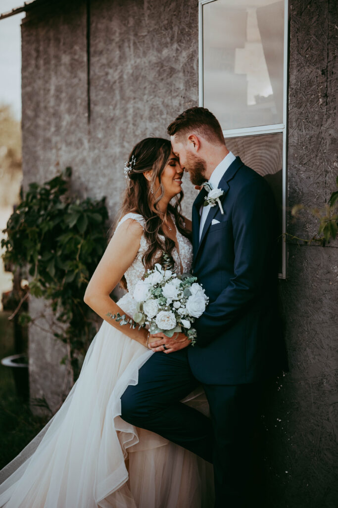couple posing on rustic barn country wedding alberta wedding photographer