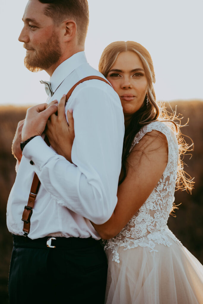 stunning bride and groom in the country walking through field cinematic feel central alberta photographer