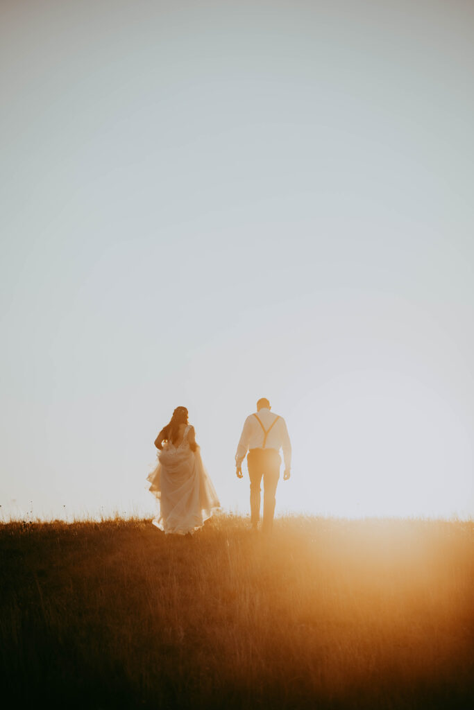 stunning bride and groom in the country walking through field cinematic feel central alberta photographer
