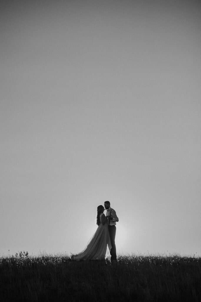 stunning bride and groom in the country walking through field cinematic feel central alberta photographer