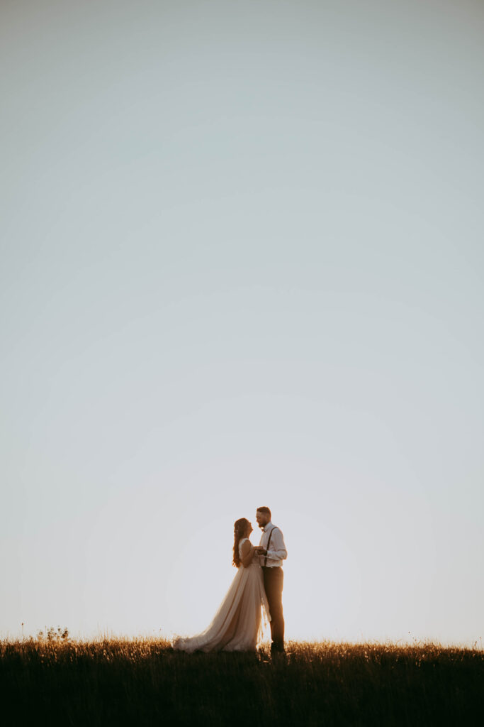 stunning bride and groom in the country walking through field cinematic feel central alberta photographer